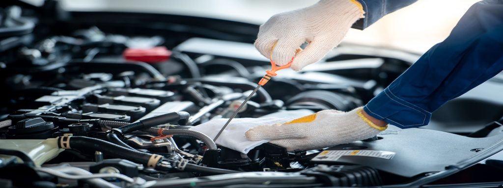 GMC Certified Maintenance Professional is servicing an engine = checking the oil